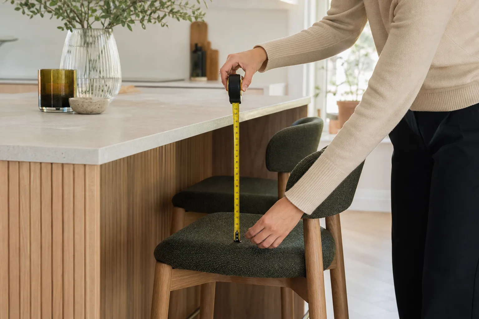 Händer som mäter avstånd mellan bänkskiva och sits