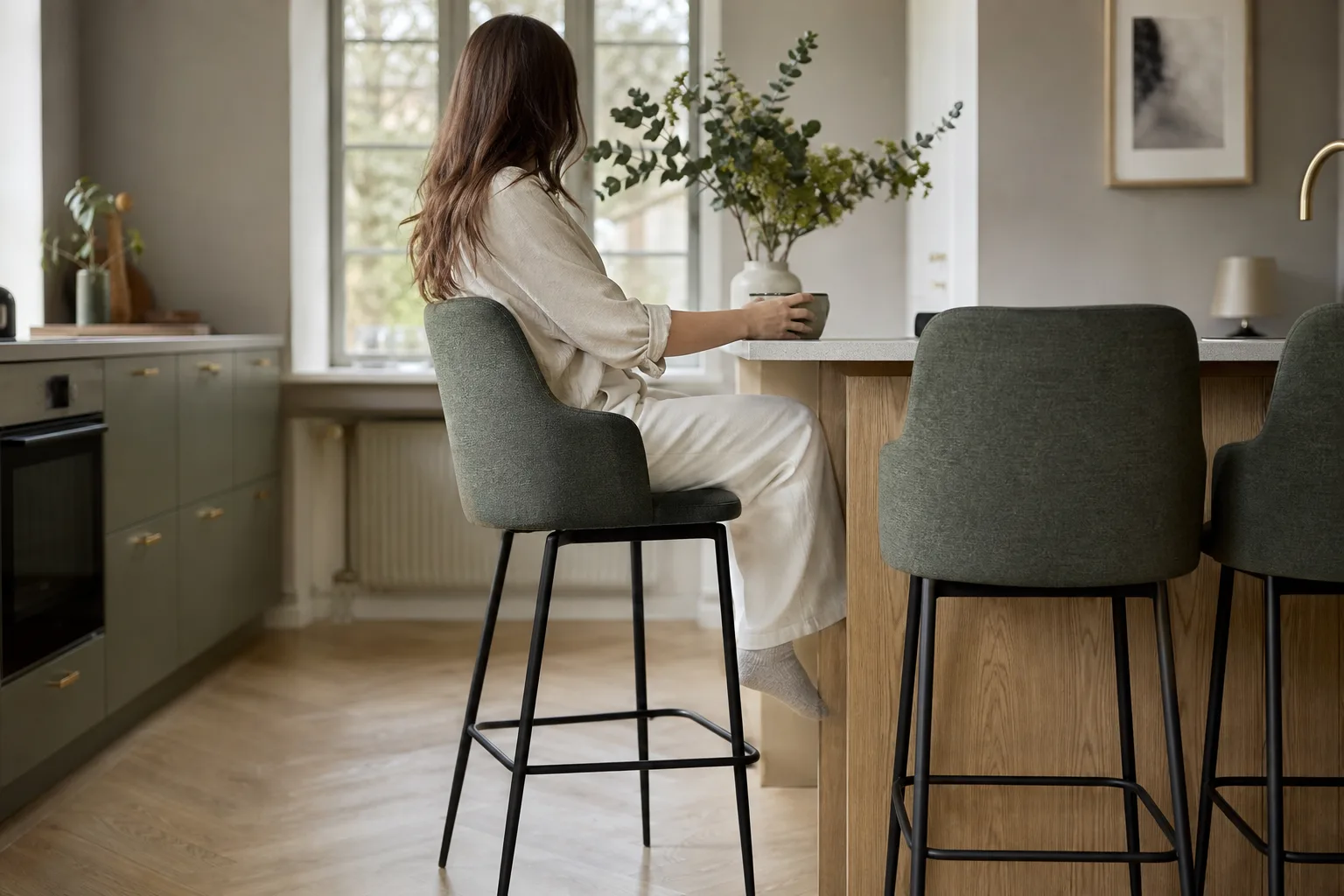 Barstol med ryggstöd sedd i profil vid en köksö