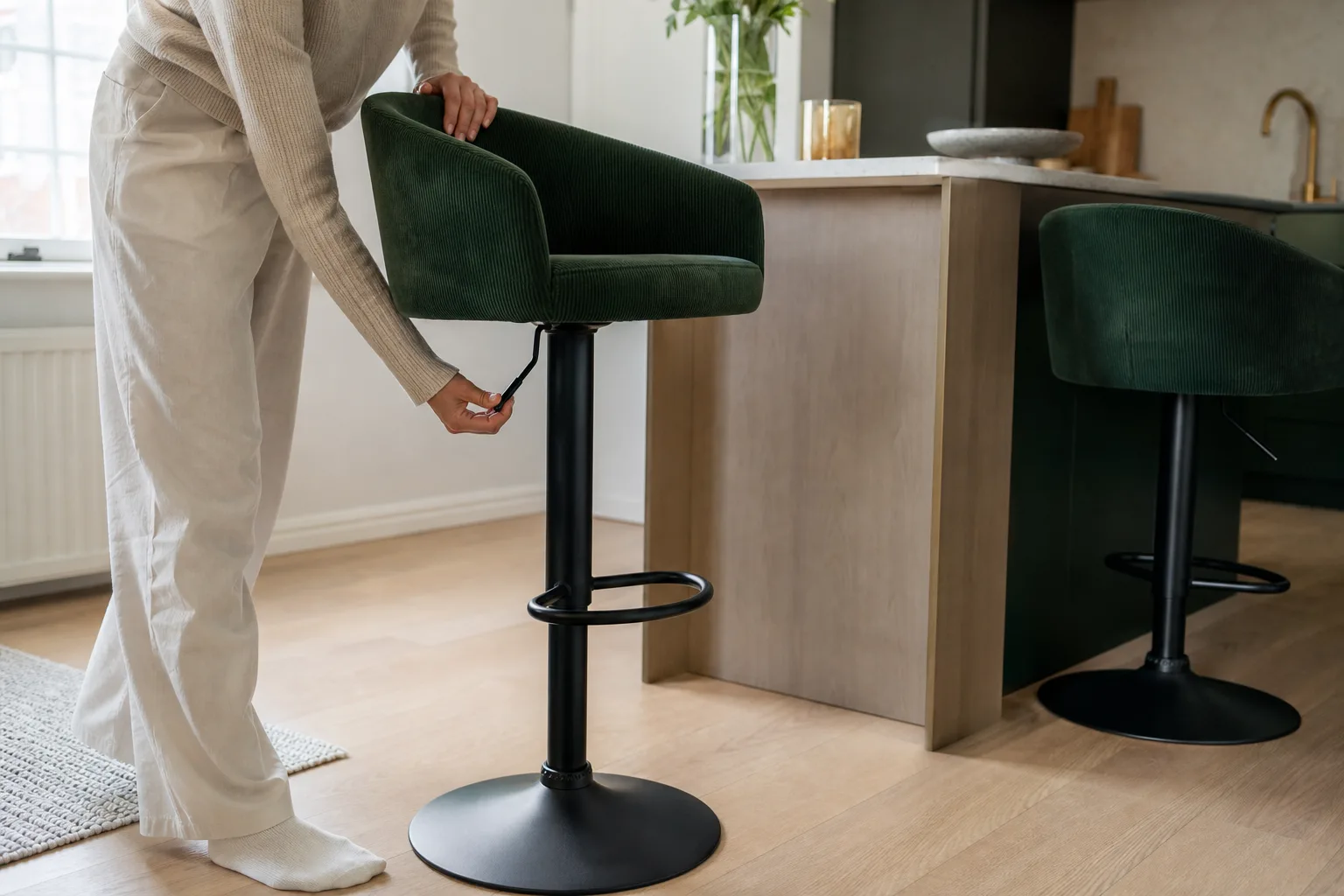 Hand som trycker ner justeringsspaken under en barstol